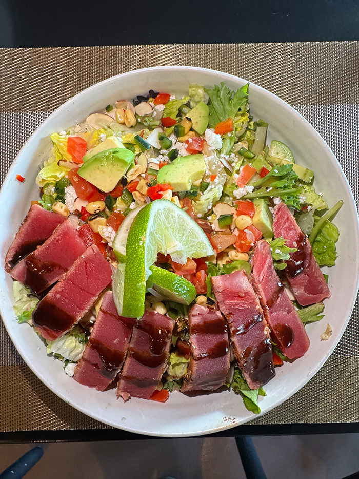 Seared ancho ahi tuna over greens with avocado, corn and balsamic drizzle