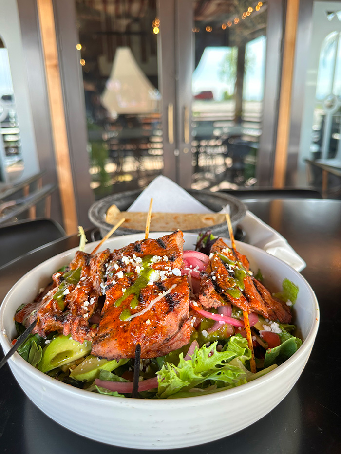 Grilled chicken kabob salad with avocado, pickled onions and cilantro drizzle