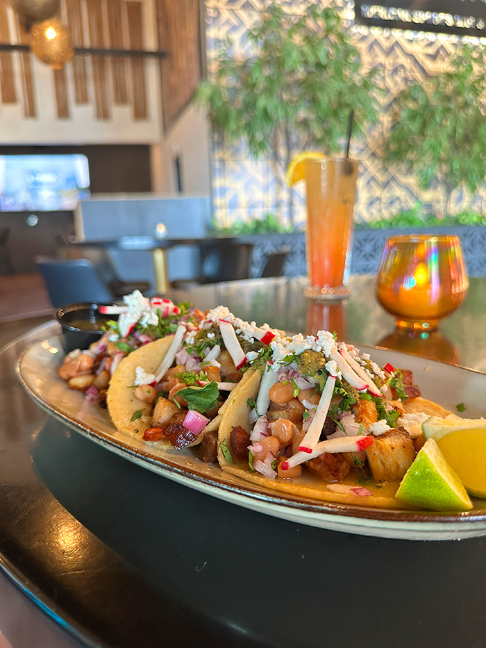 Three street tacos with radishes, cilantro and queso fresco in the dining room