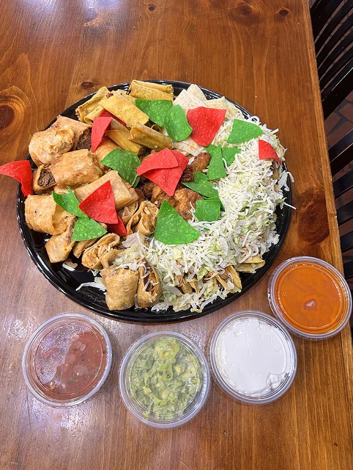 Actual takeout Party Platter with four dip cups — salsa, guacamole, sour cream, and hot sauce